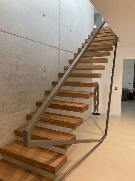 Kragarmtreppe mit Eichenstufen und Geländer aus Stahl